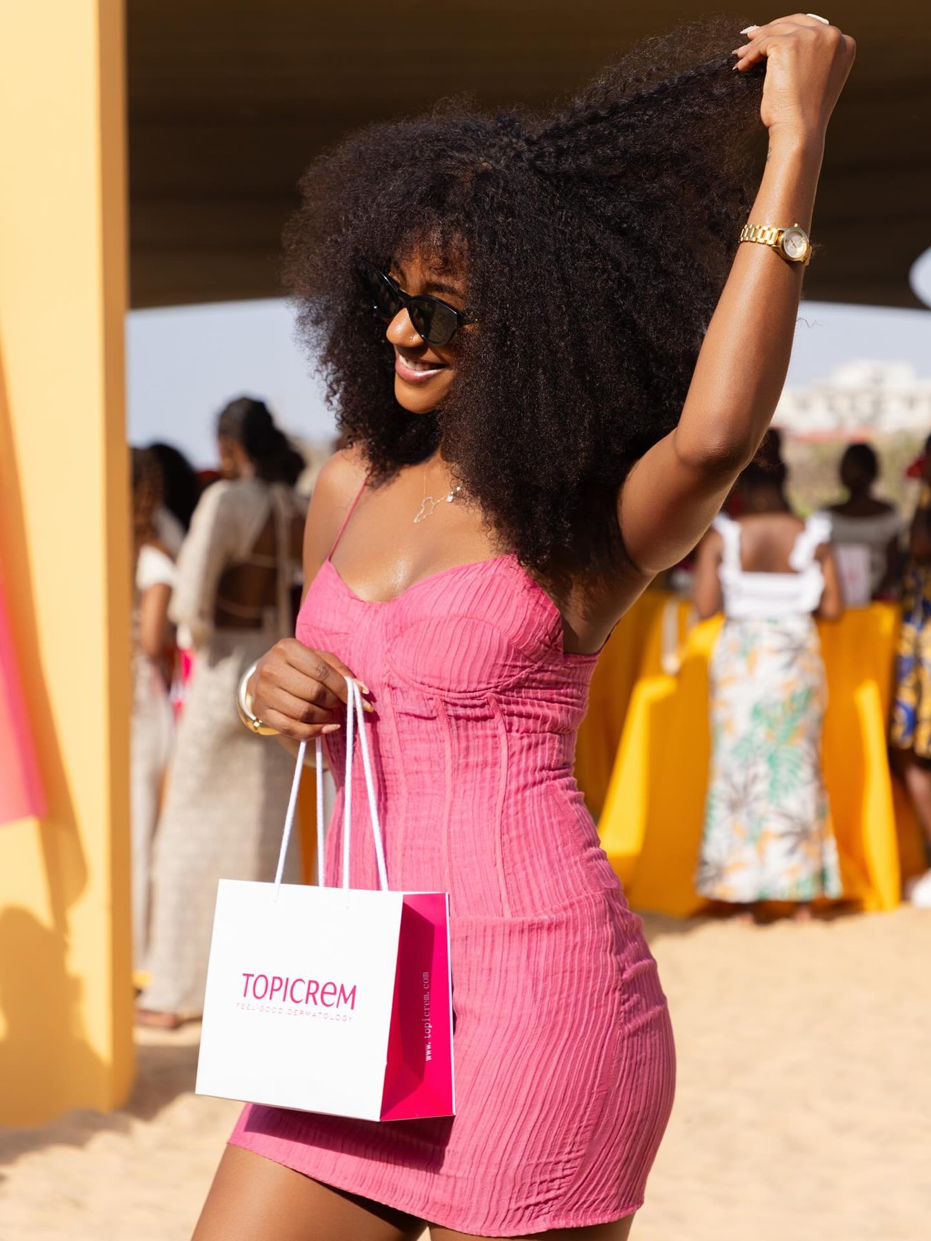 Amy Lucia Diop en robe rose, lunettes de soleil, lors d'un événement en plein air à Dakar